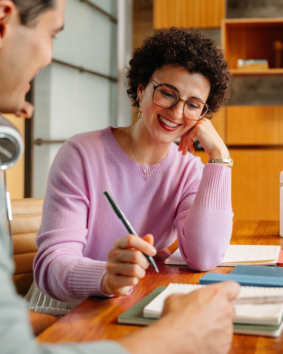 A professional writing notes at her desk